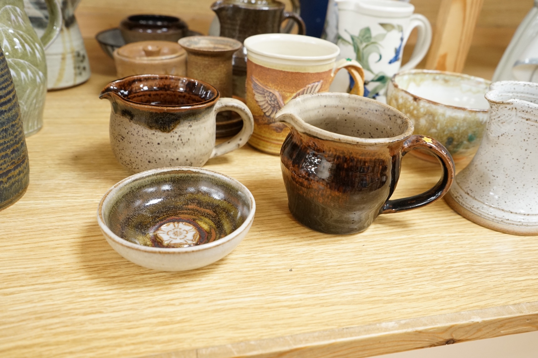 A large collection of studio pottery mugs bowls and jugs, tallest jug 21cm.